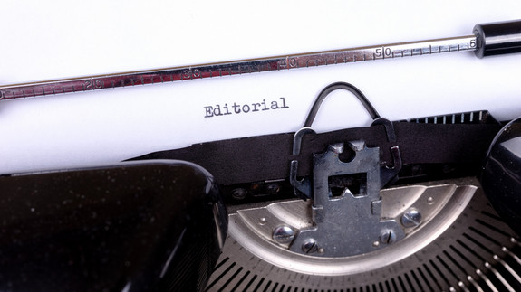 Schreibmaschine tippt das Wort Editorial auf Papier