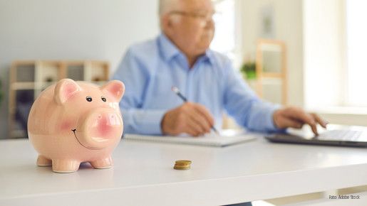 Sparschwein mit Mann im Hintergrund