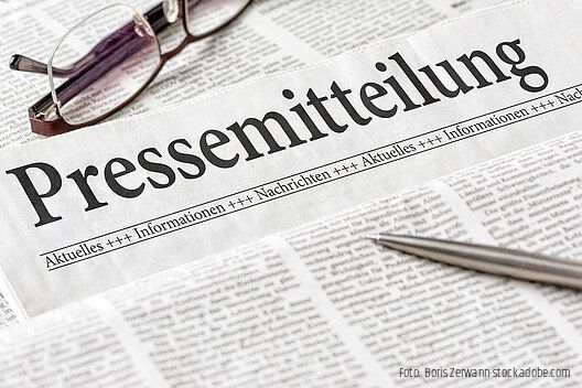 Zeitung mit der Überschrift Pressemitteilung mit brille und kuli
