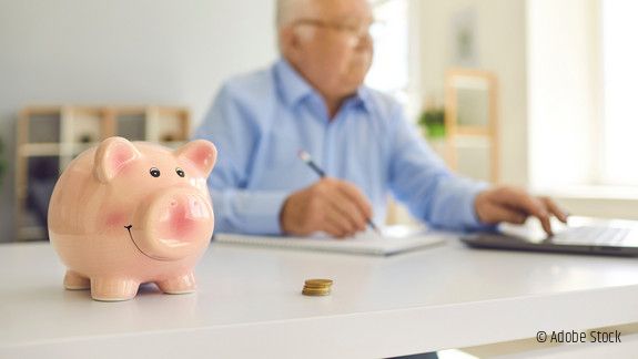 Sparschwein mit Mann im Hintergrund