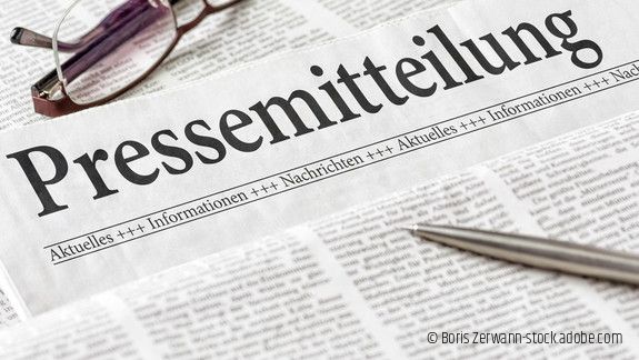 Zeitung mit der Überschrift Pressemitteilung mit brille und kuli