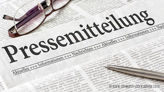 Zeitung mit der Überschrift Pressemitteilung Zeitung mit der Überschrift Pressemitteilung mit brille und kuli