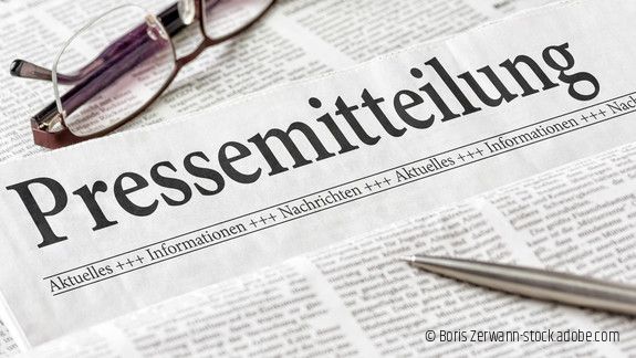 Zeitung mit der Überschrift Pressemitteilung mit brille und kuli